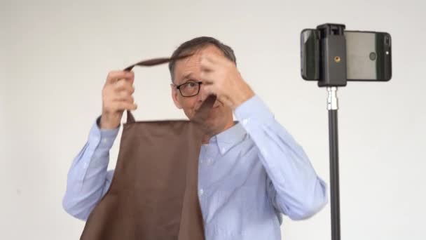 En äldre manlig bloggare förbereder sig för att börja sända — Stockvideo