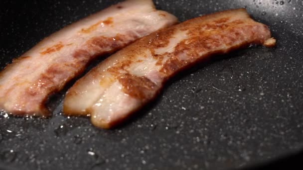 Vista de perto das fatias de bacon na frigideira. — Vídeo de Stock