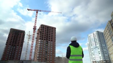 İnşaat alanındaki danışman mühendis elinde planı tutuyor. İnşaat müfettişi. İnşaat alanı teftiş çizimi ve yeni inşaat iş akışı