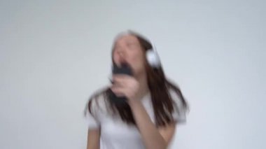  Kulaklıklı Mutlu Kız Dans ediyor ve şarkı söylüyor