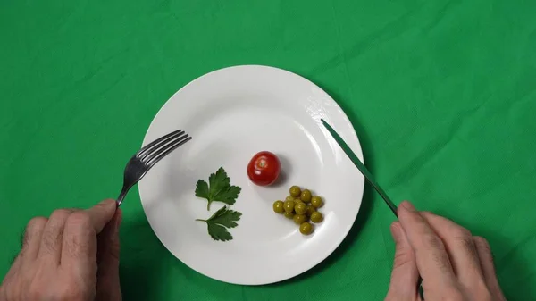 Egy férfi keze közelebb kerül egy tányér sovány ételhez. Adagolás ellenőrzés. A koncepció a fogyás és az egészséges táplálkozás. Természetes összetevők. Zöldségek és egészséges táplálkozás. Felülnézet — Stock Fotó