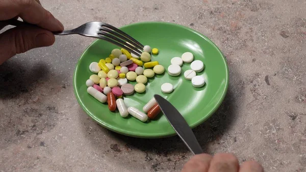 Jedzenie pigułek zamiast jedzenia. Tabletki na zielonym talerzu z widelcem. Pigułka zamiast jedzenia. dieta — Zdjęcie stockowe