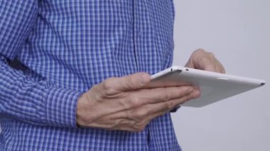 Elinde tablet bilgisayar tutan bir adam.