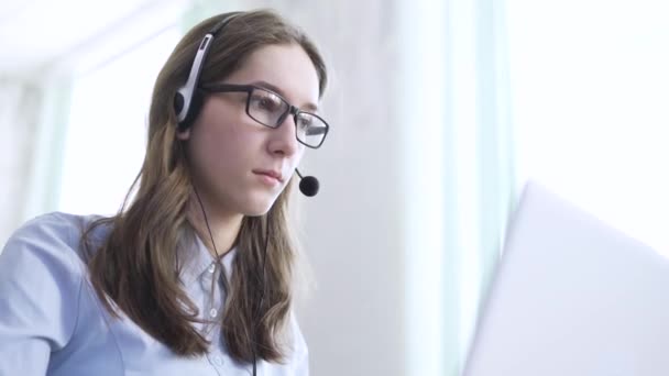 Komoly call center üzemeltető vezeték nélküli headset beszél az ügyféllel, közelről — Stock videók