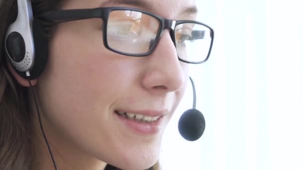 Közelkép egy fiatal lány arcáról, aki fülhallgatót visel, online kommunikál, magyarázza, tanít. — Stock videók