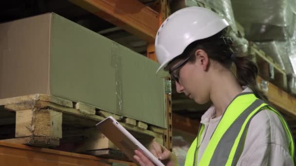 Дівчина-контролер у шоломі та жилеті під час заводського огляду — стокове відео