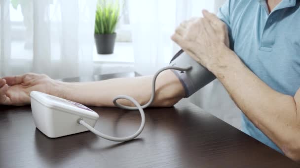 Starší muž si měří krevní tlak. — Stock video