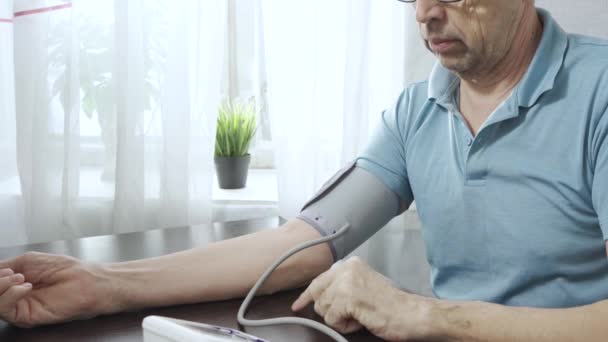 Idoso mede sua própria pressão arterial com um tonômetro — Vídeo de Stock