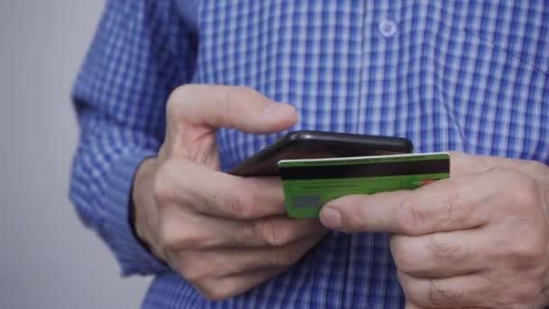 Primer plano de las manos del hombre que sostiene la tarjeta de crédito y el uso de smartphone. — Vídeo de stock
