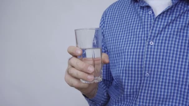 En man håller ett glas vatten i handen — Stockvideo