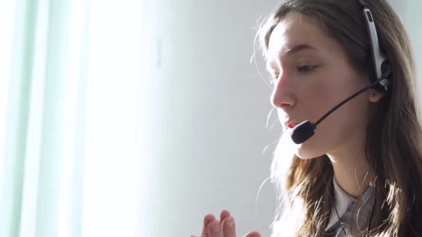 Operador serio del centro de llamadas en auriculares inalámbricos hablando con el cliente, de cerca — Vídeos de Stock