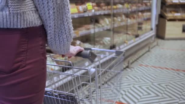 Молодой покупатель с тележкой в супермаркете — стоковое видео
