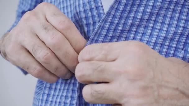 Un bărbat în vârstă se luptă să-și butoneze hainele — Videoclip de stoc