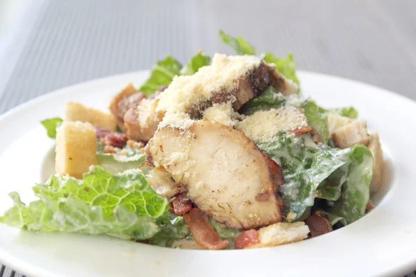 Salade de cæsar de poulet dans une assiette blanche — Photo