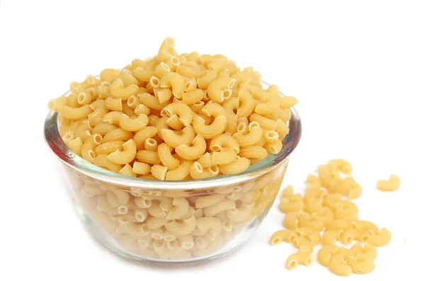 Macaroni in een glazen kom op witte achtergrond — Stockfoto