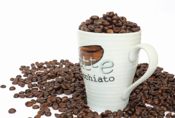 Cup full av kaffebönor på vit bakgrund — Stockfoto