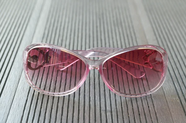 Pink sunglasses put on the wooden table — Stock Photo, Image
