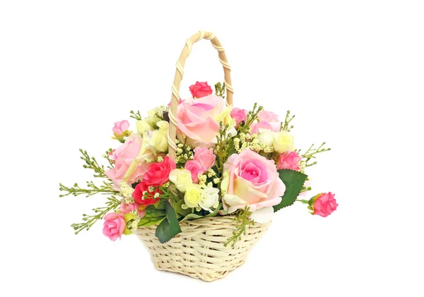 Hermosas rosas en una cesta blanca aislada en blanco Imagen de archivo