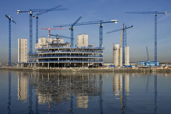 Construction cranes building a waterside office development — Stock Photo, Image