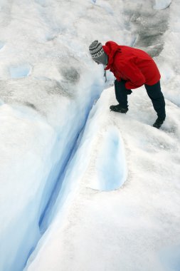 Tourist looking into a crevasse - Argentina clipart