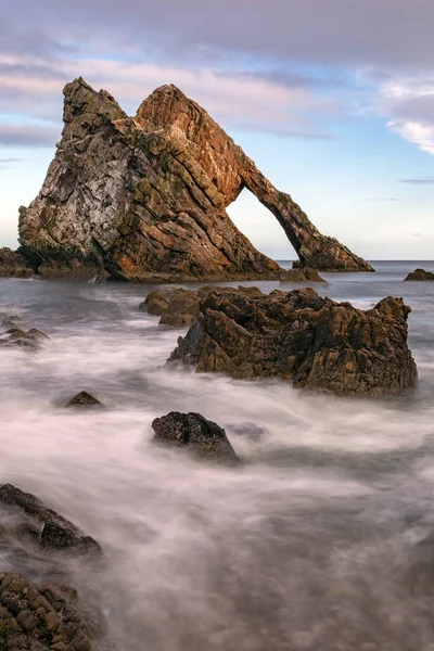 フィドル ロック Bow Fiddle Rock スコットランド北東部のポートノッキー近くの天然の海のアーチ 石英質砂岩を起源とする変成岩の石英 この岩はカレン珪岩層の一部である — ストック写真