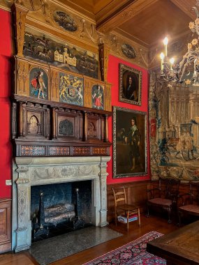 İngiltere, Cheshire 'da Disley yakınlarında Lyme Hall' da sıva avlanma sahnesi ve arma ile süslü şömine..