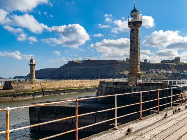 Deniz feneri ve rıhtım İngiltere 'nin kuzeydoğu kıyısındaki Whitby kıyı kasabasının girişinde..