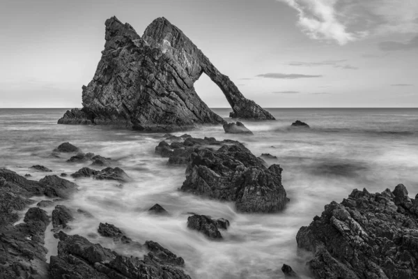 フィドル ロック Bow Fiddle Rock スコットランド北東部のポートノッキー近くの天然の海のアーチ 石英質砂岩を起源とする変成岩の石英 この岩はカレン珪岩層の一部である — ストック写真