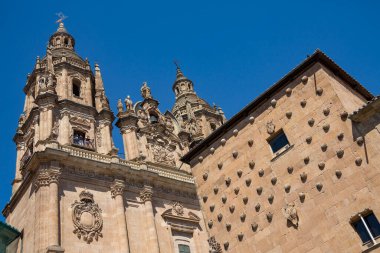 İspanya 'nın Castilla-y-Leon bölgesindeki Salamanca şehrindeki Universidad' ın çan kulesinde turistler. Öndeki bina 16. yüzyılda inşa edilen Casa de la Conchas (Kabuk Evi) ve şimdi bir kütüphane..
