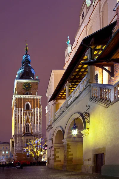 ポーランドのクラクフの主要な市場広場 Rynek Glowny にある町役場の塔と布のホールの南側の夜景 — ストック写真