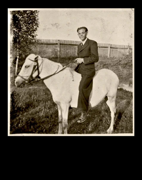 Un uomo siede su un piccolo pony — Foto Stock