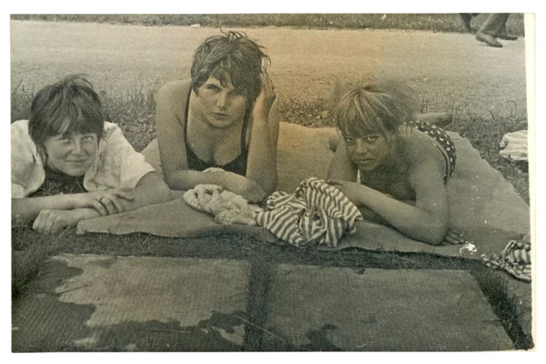 Friends - three young women in a blanket (sunbathing by the water) — Stock Photo, Image