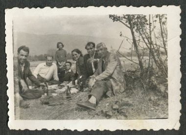 oturan bir grup insan (çoğunlukla erkekler)