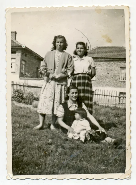 Три женщины и один сидящий ребенок — стоковое фото