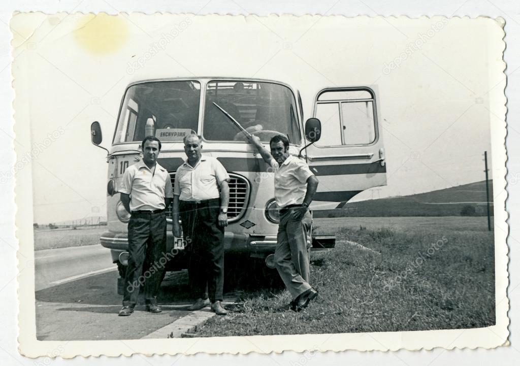 Men standing in front of the bus