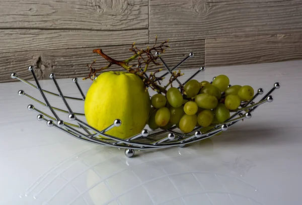 Zielone jabłko i zielone winogrona na białym stole zbliżenie — Zdjęcie stockowe