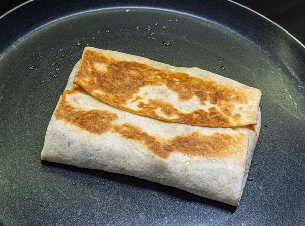 Fried pita on a black frying pan top view — Stock Photo, Image