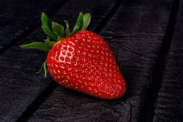 Ripe strawberries on a black background close up — Photo