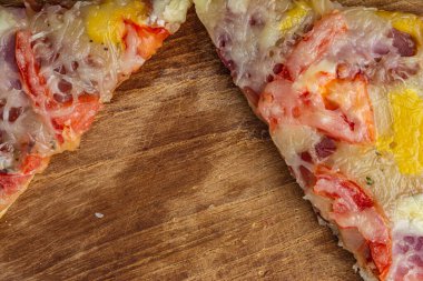 Yuvarlak tahta üzerinde iki dilim pizza.