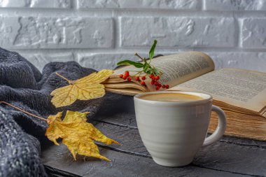 Renkli sonbahar akçaağaç yaprakları, ahşap dokuda kitap ve bir fincan kahve. Yüksek kalite fotoğraf