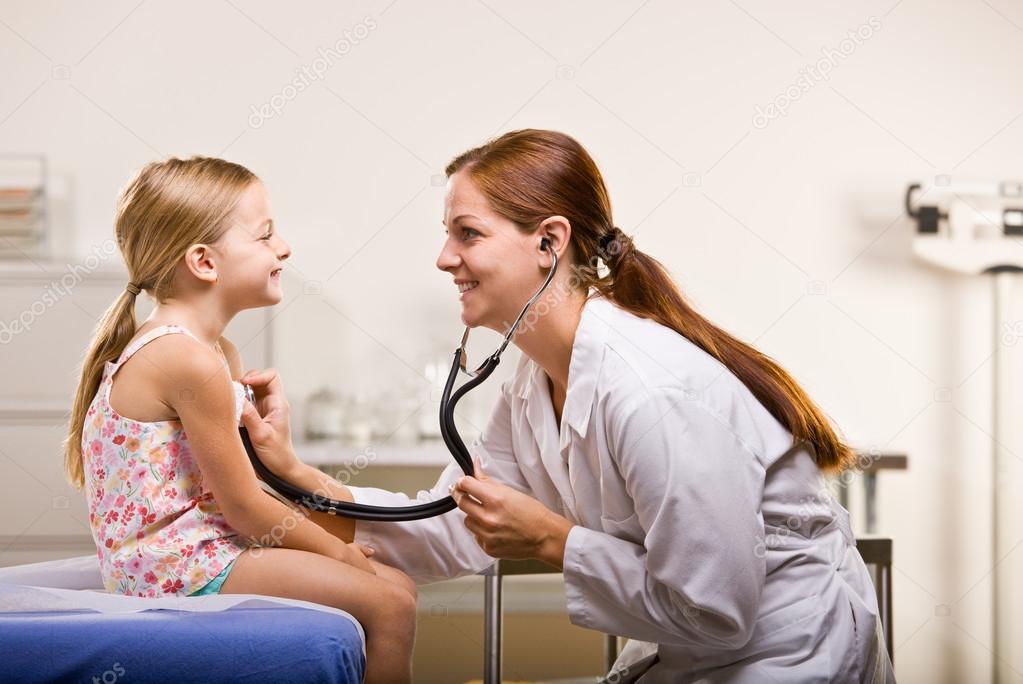 Doctor giving girl checkup in doctor office