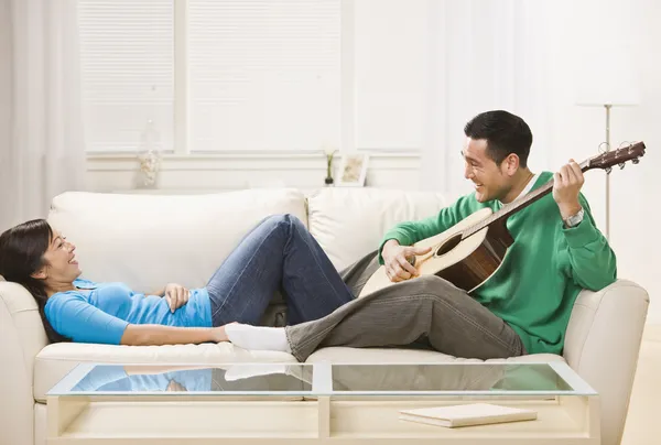 Asian couple on couch relaxing together. — Stock Photo, Image