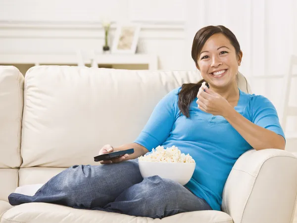 Mooie vrouw op de Bank eten popcorn — Stockfoto