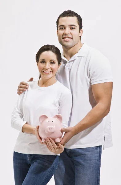 Aantrekkelijke jonge paar met piggy bank — Stockfoto