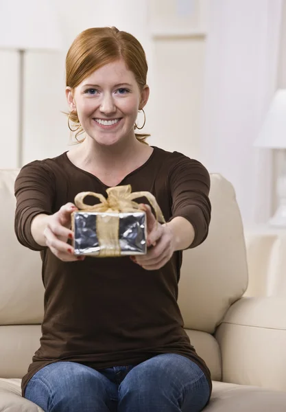 Frau überreicht Geschenk an die Kamera — Stockfoto