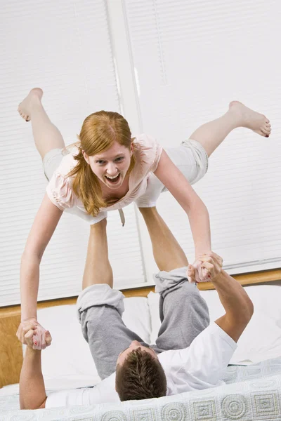 Casal jogando na cama juntos . — Fotografia de Stock