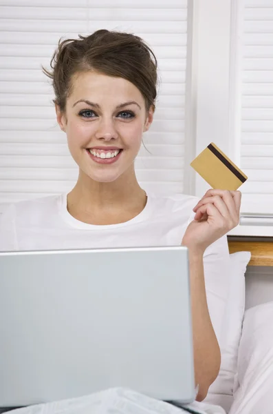 Donna sorridente in possesso di carta di credito — Foto Stock