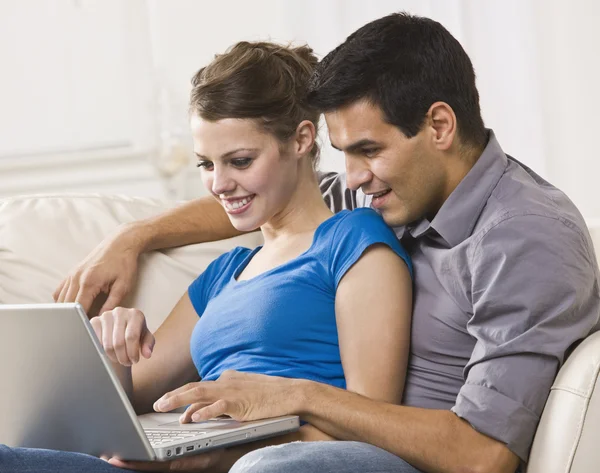 Casal atraente trabalhando no laptop juntos — Fotografia de Stock