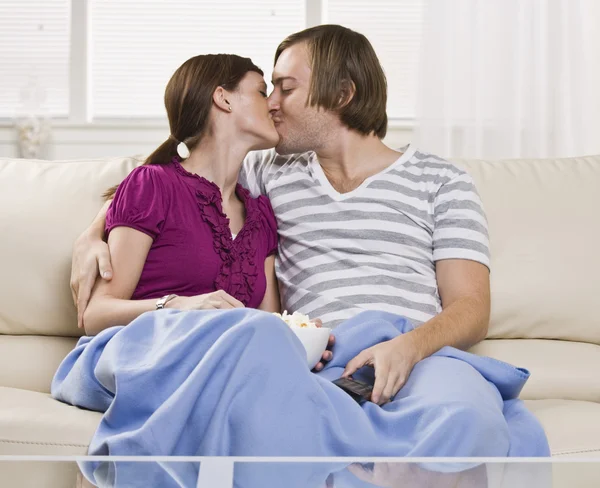 Couple kissing on couch — Stock Photo, Image