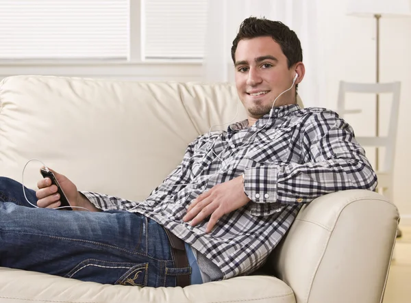 Attractive brunette male sitting on couch. — Stock Photo, Image